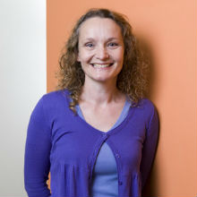 Juliet osborne in purple top with peach background